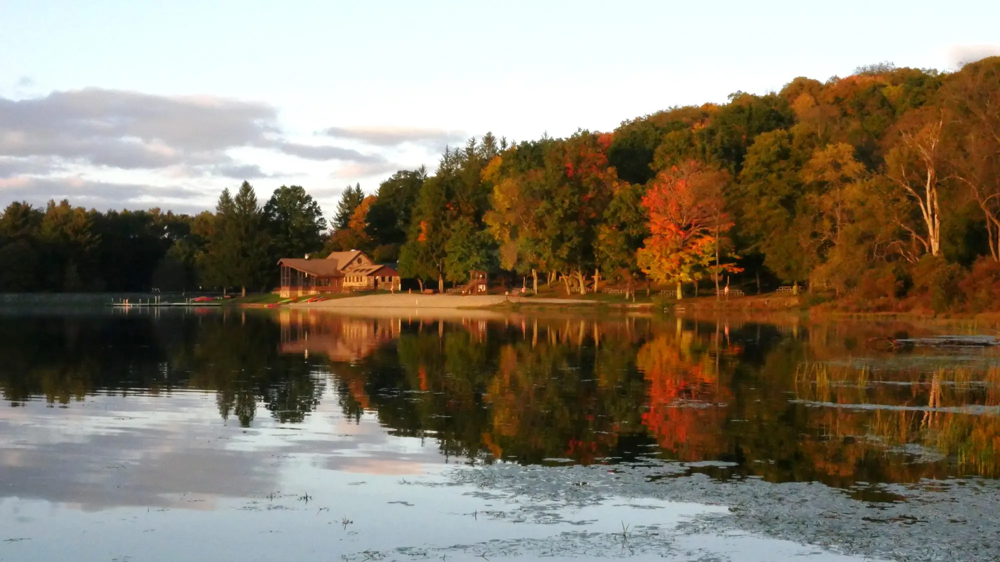 Herrington Manor's lake mirroring a shoreline in full October color