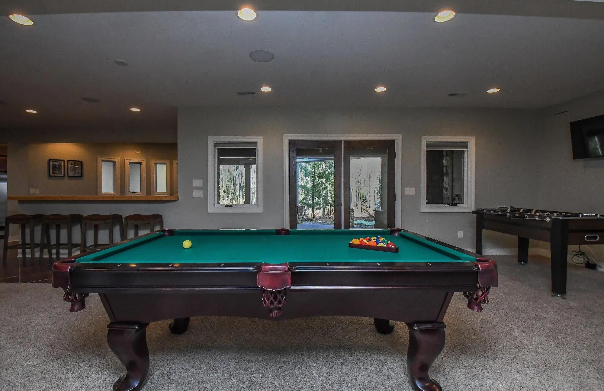 Lower-level game room with a pool table and foosball at Woodland Chalet
