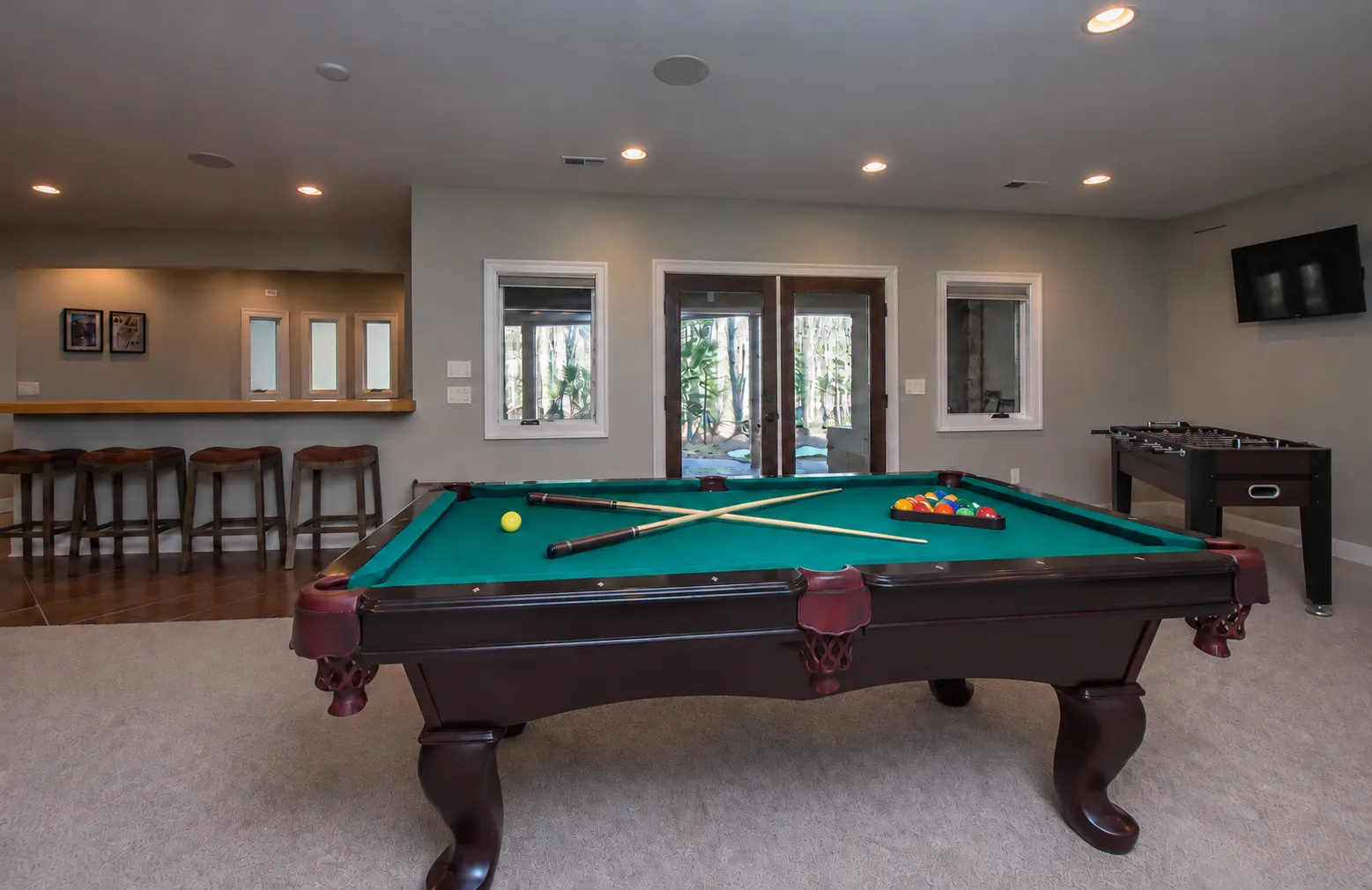 Lower-level game room with a pool table and foosball at Woodland Chalet