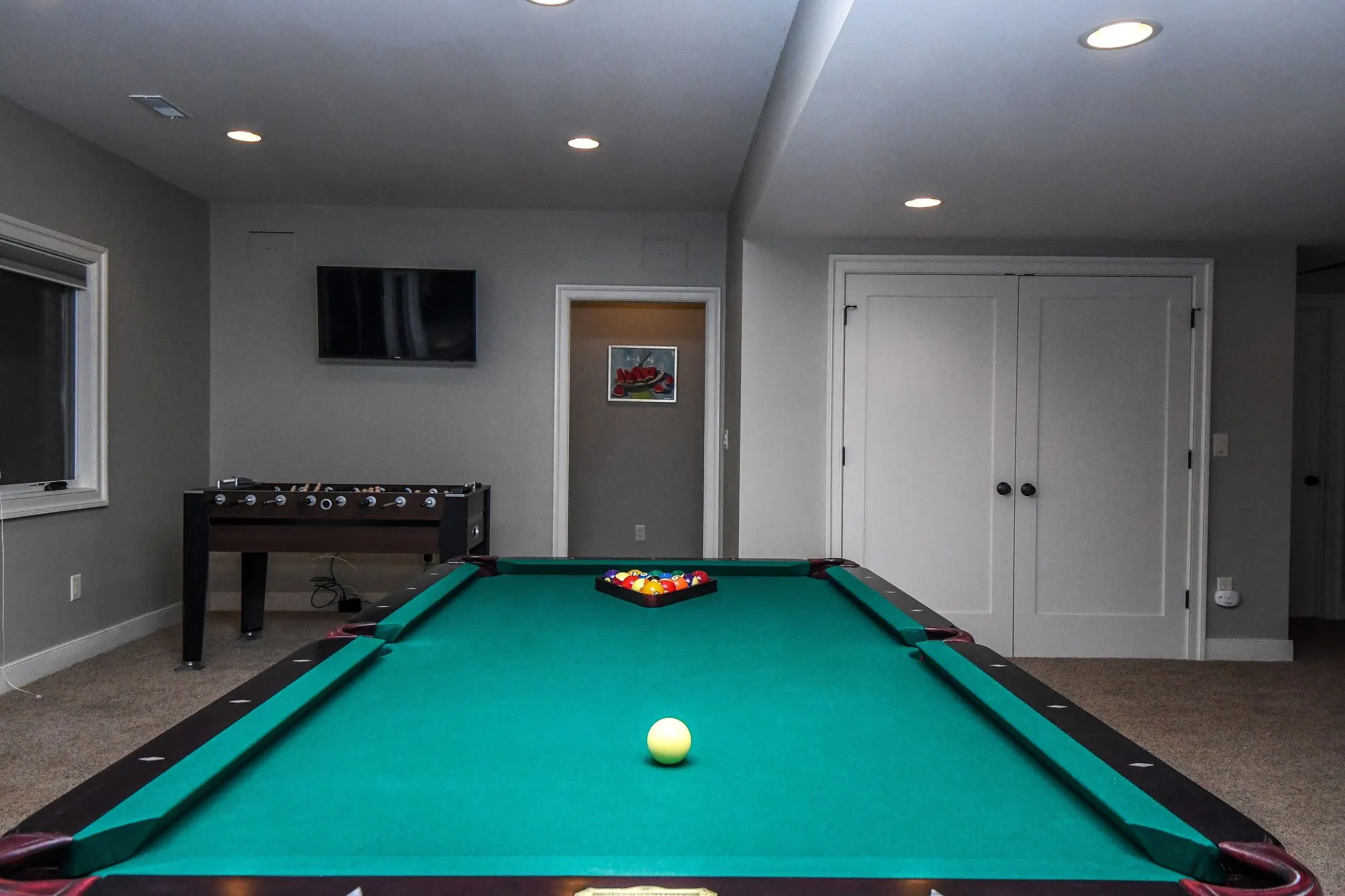 Pool table racked and ready in the lower level game room