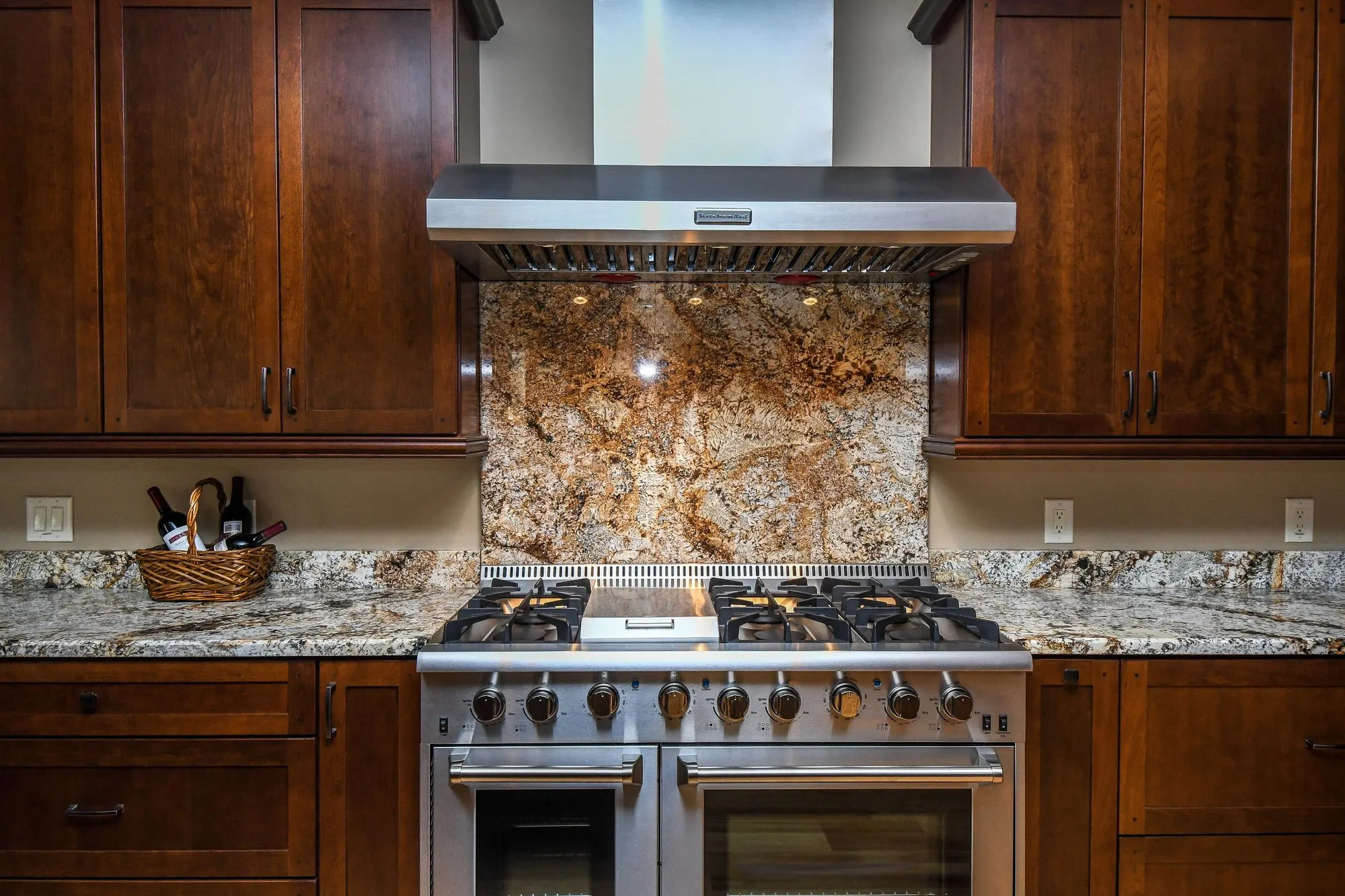 Main kitchen gas range and granite backsplash up close