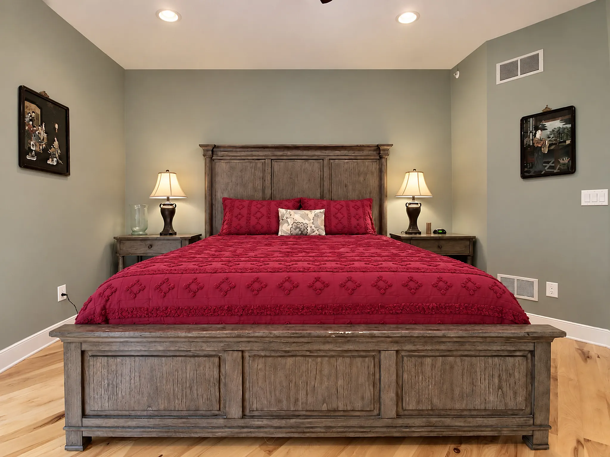 Deck-access king bedroom with paneled headboard and warm red bedding