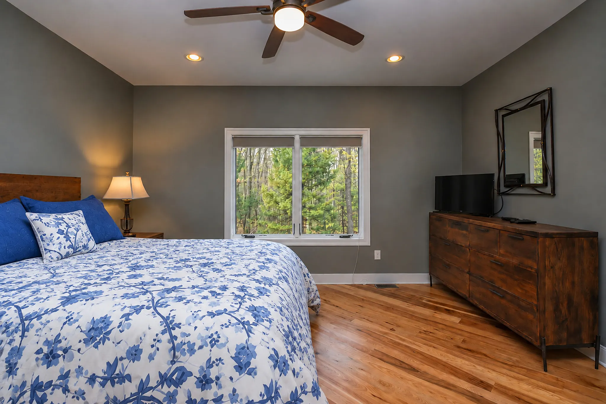 Main level bedroom with sage bedding and a dresser