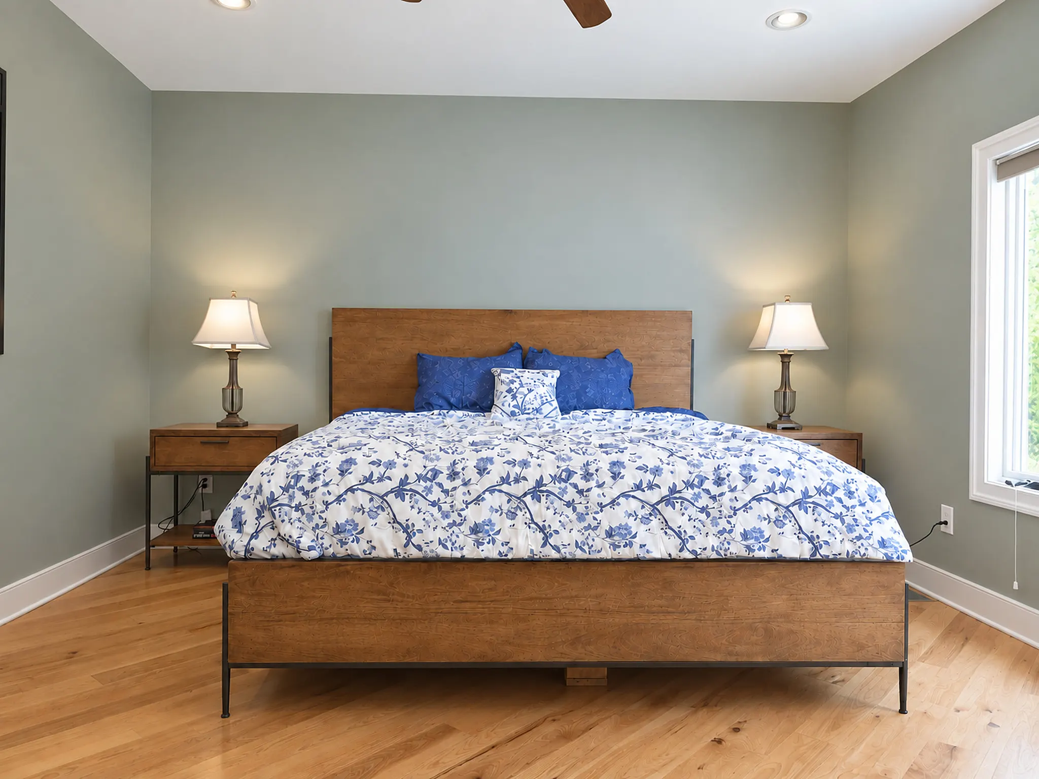 King bedroom with a wood platform bed and sage green walls