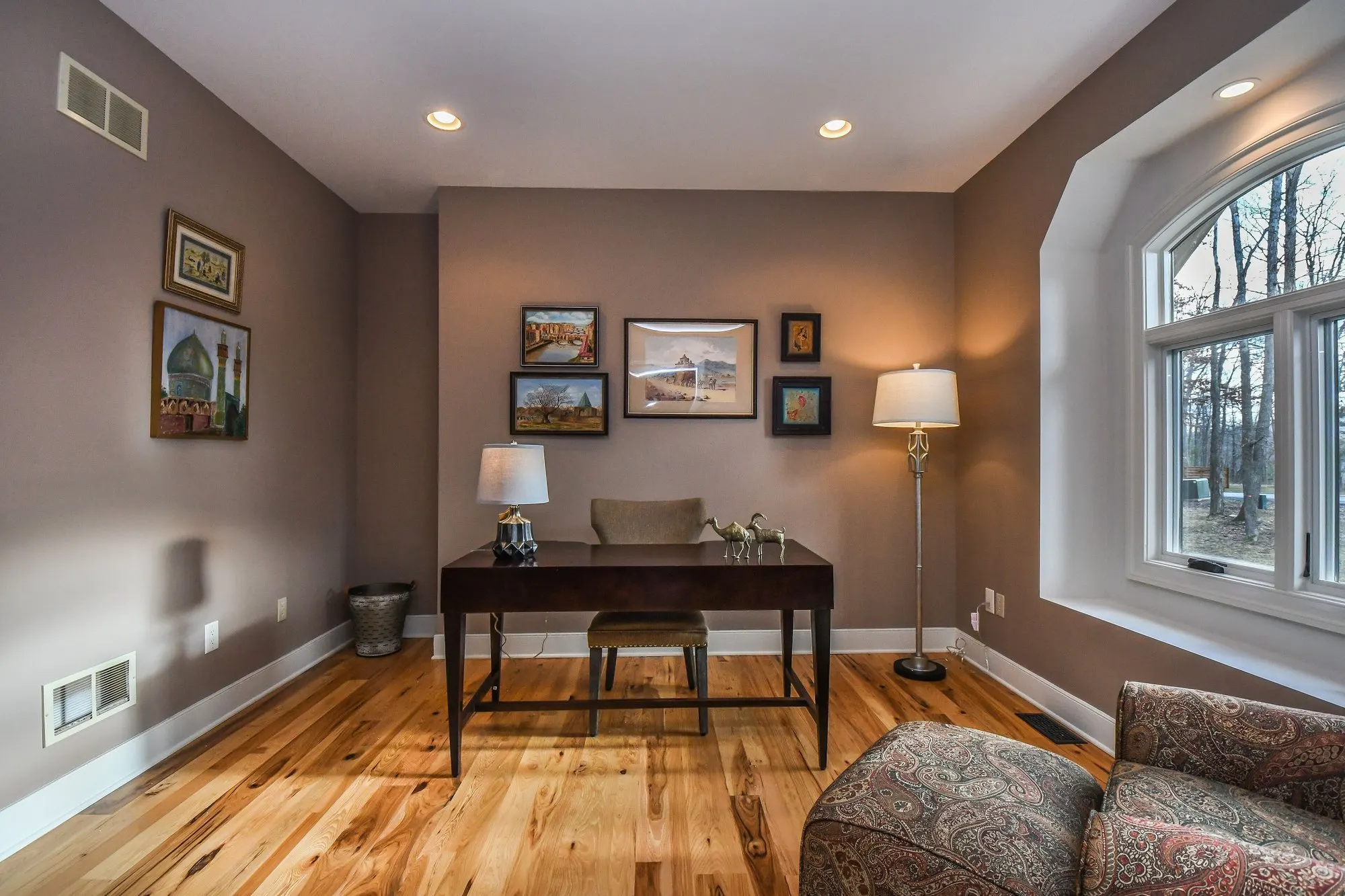 Home office desk beneath the arched window