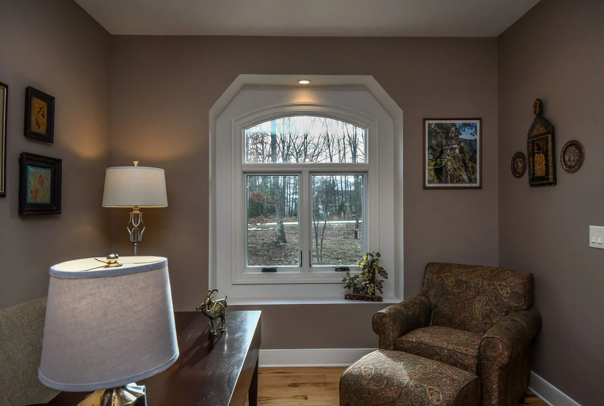 Home office reading chair beneath the arched window