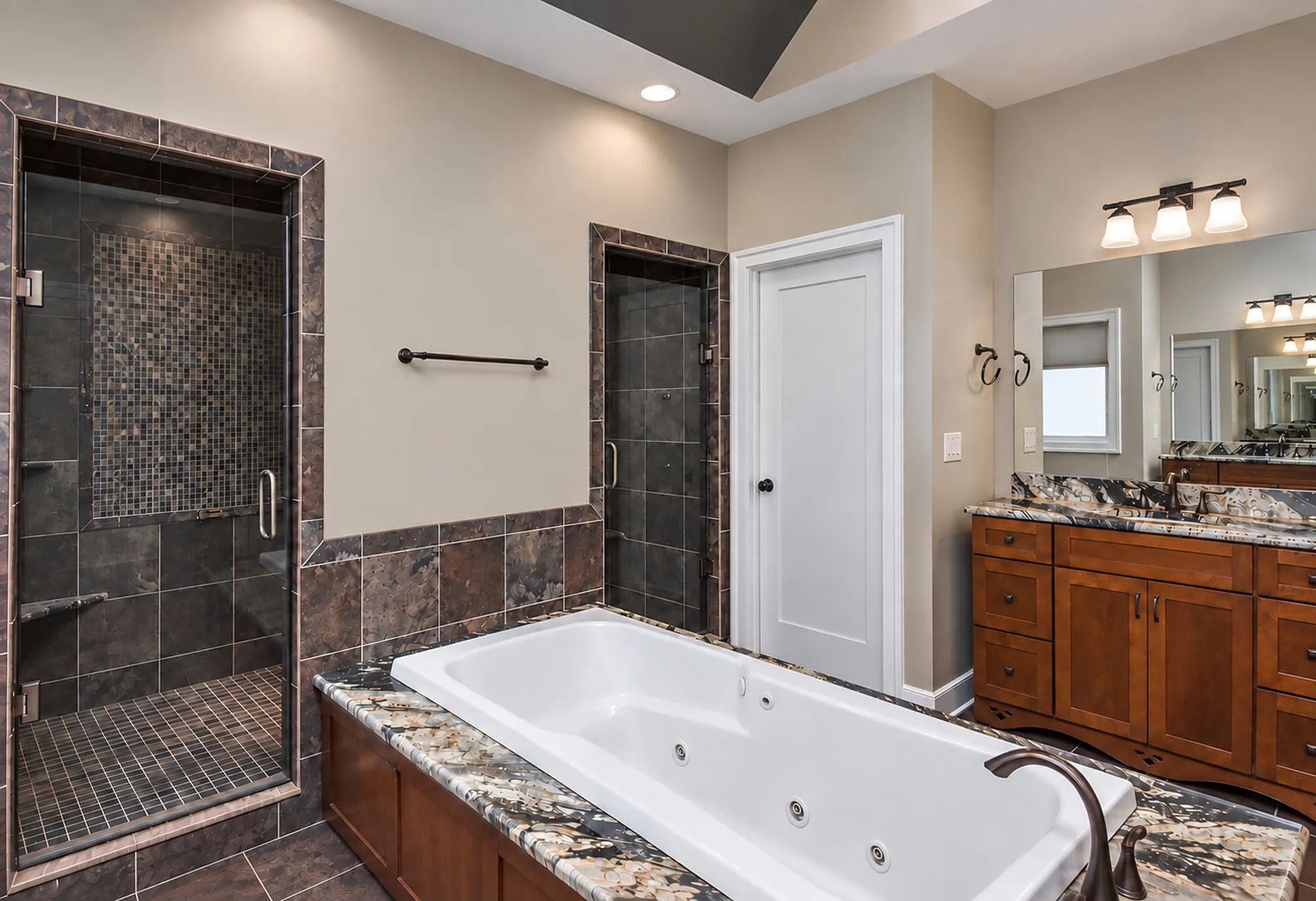 Walk-in tile shower and tub in the primary suite bathroom