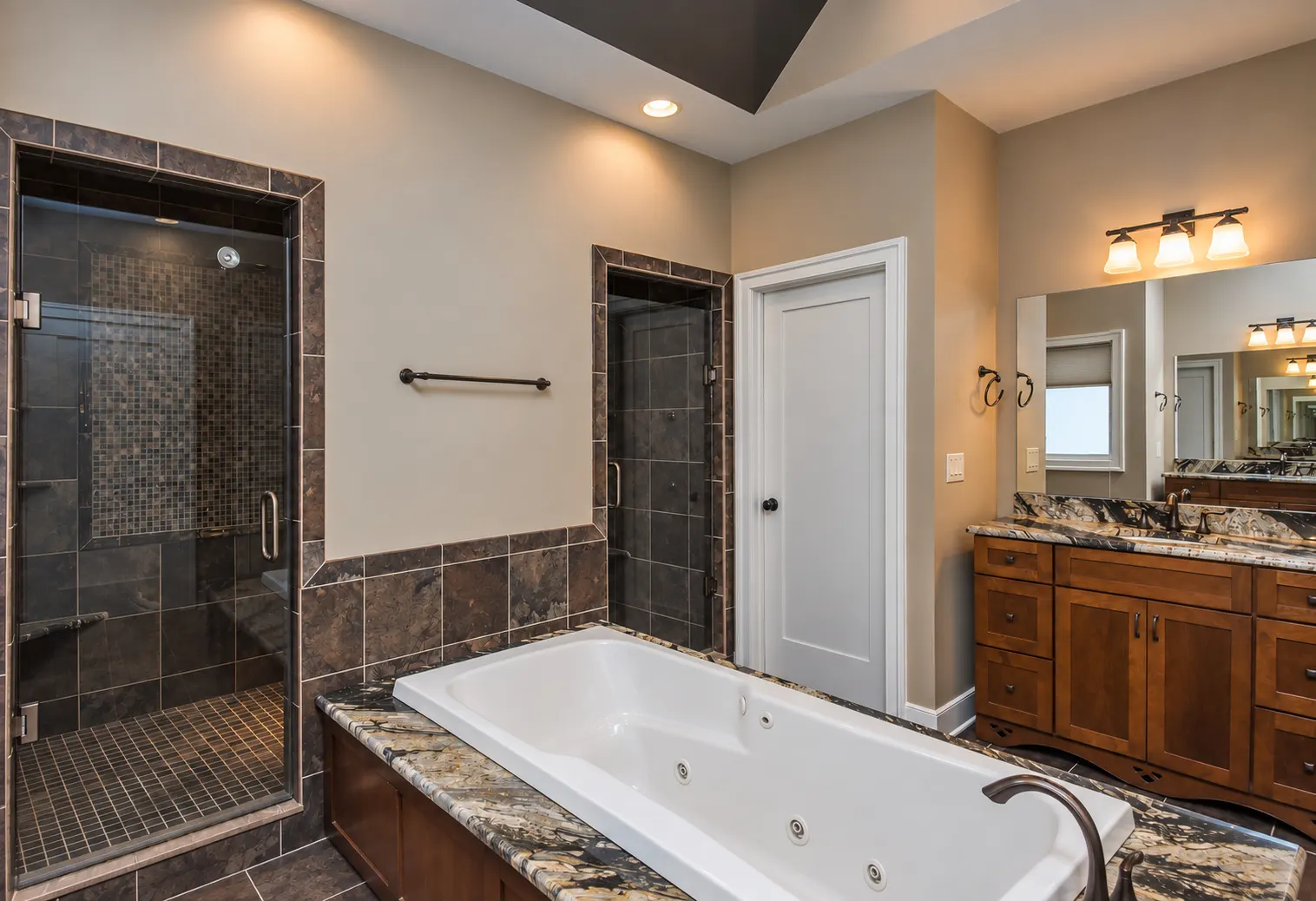Spa-style walk-in shower with tile surround in the primary suite bathroom