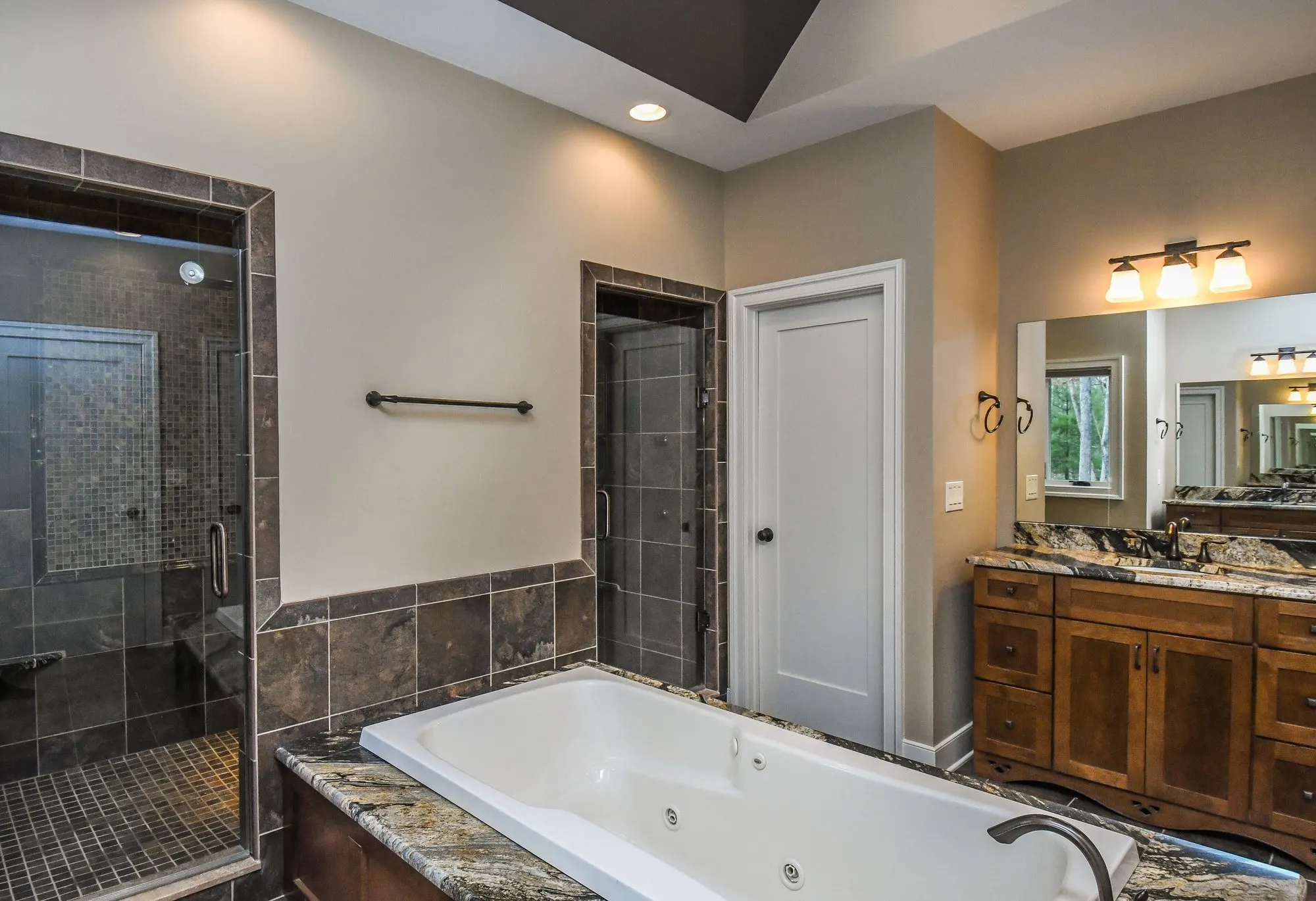 Spa-style walk-in shower with tile surround in the primary suite bathroom