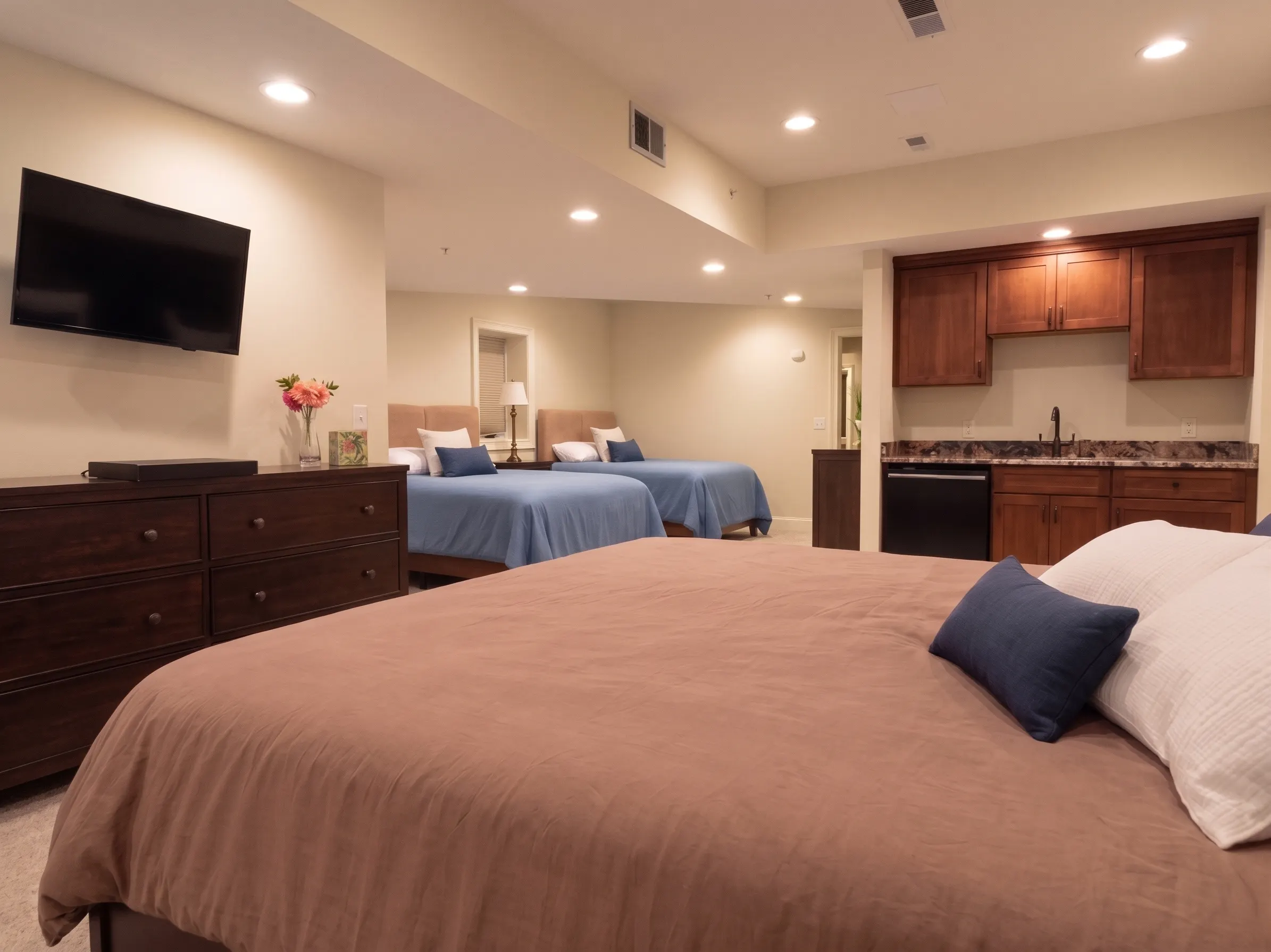 Lower level second suite with king bed, guest beds, and kitchenette