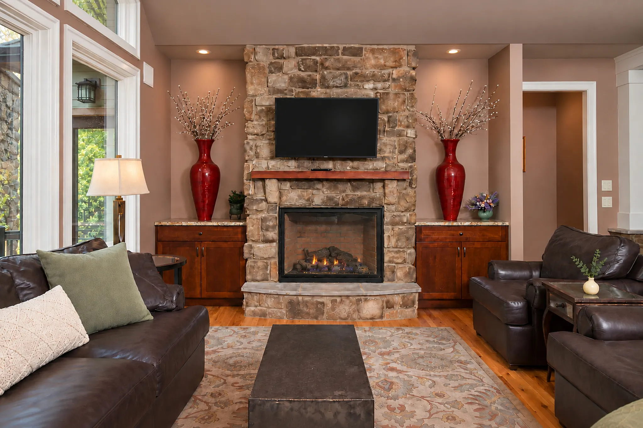 Sitting room with the corner stone fireplace and television centered