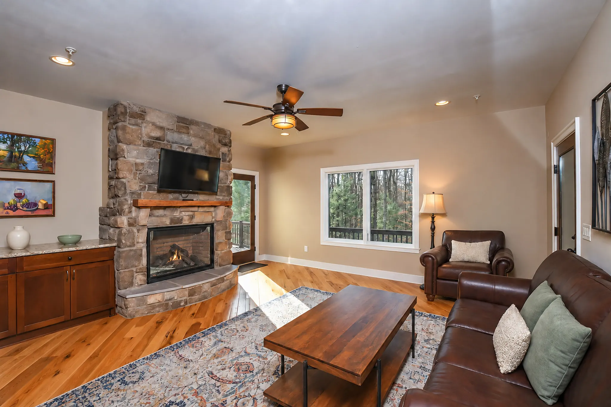 Sitting room with a corner stone fireplace and leather seating