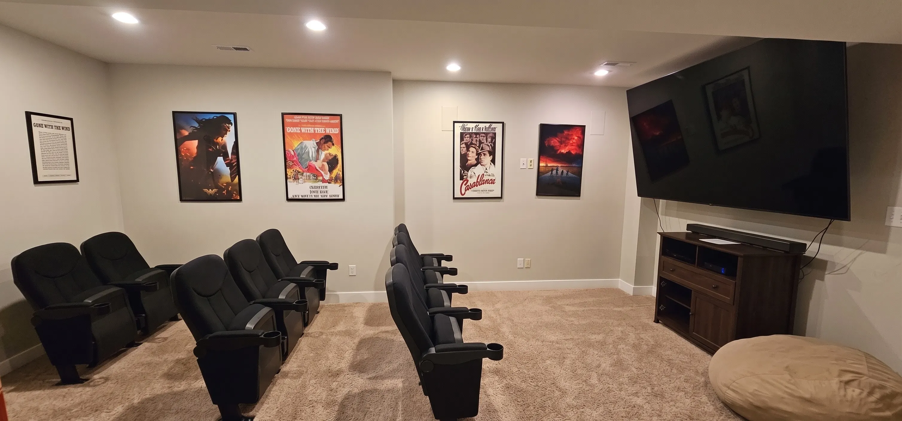 Movie theater with two rows of cinema seating and a wall-mounted big screen