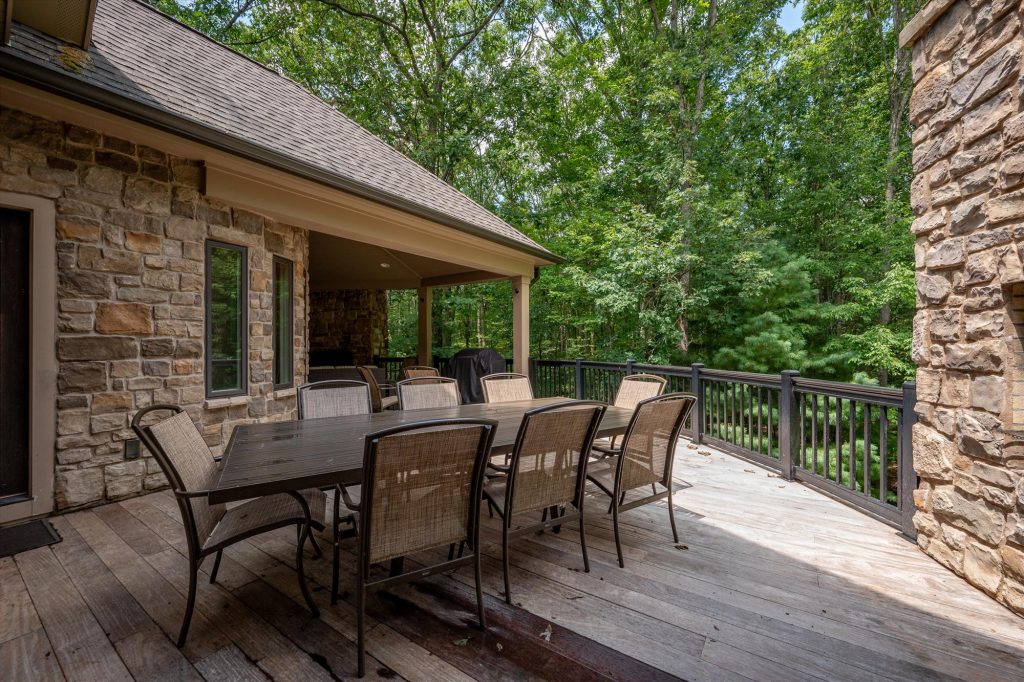 Deck seating area with Adirondack chairs overlooking the wooded hillside