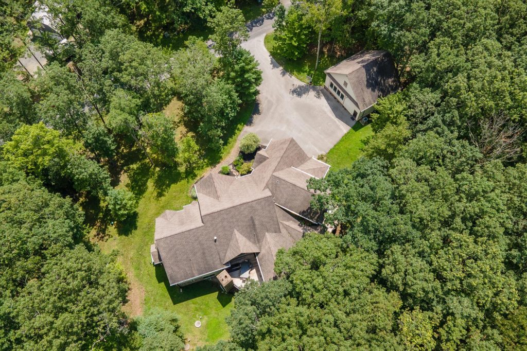 Aerial drone view of Woodland Chalet surrounded by forest near Deep Creek Lake