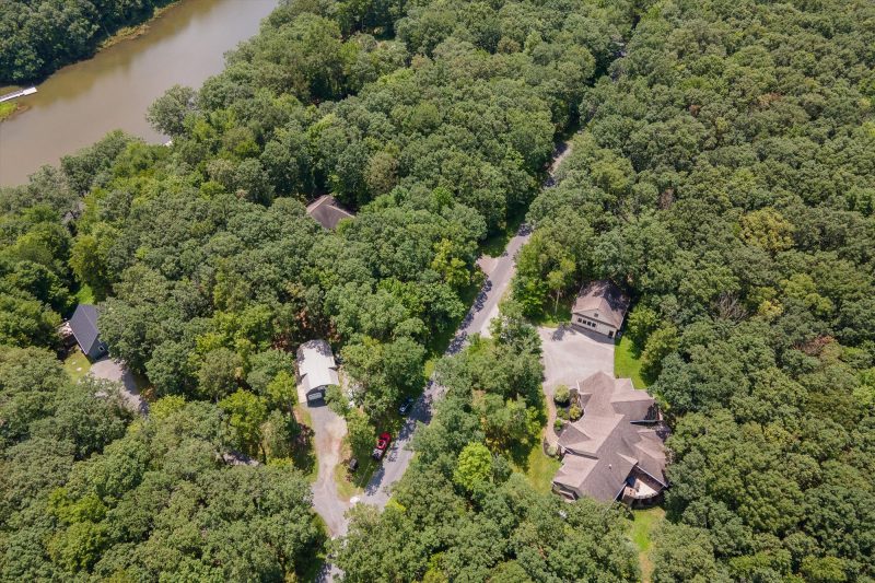 Drone view showing Woodland Chalet property and pool house from above the treetops