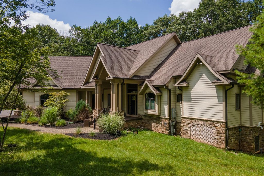 Full exterior view of the three-level Woodland Chalet in wooded mountain setting