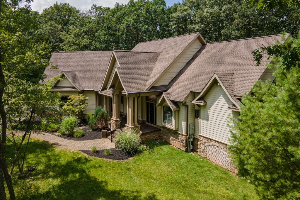 Rear exterior of Woodland Chalet highlighting wraparound deck and natural setting