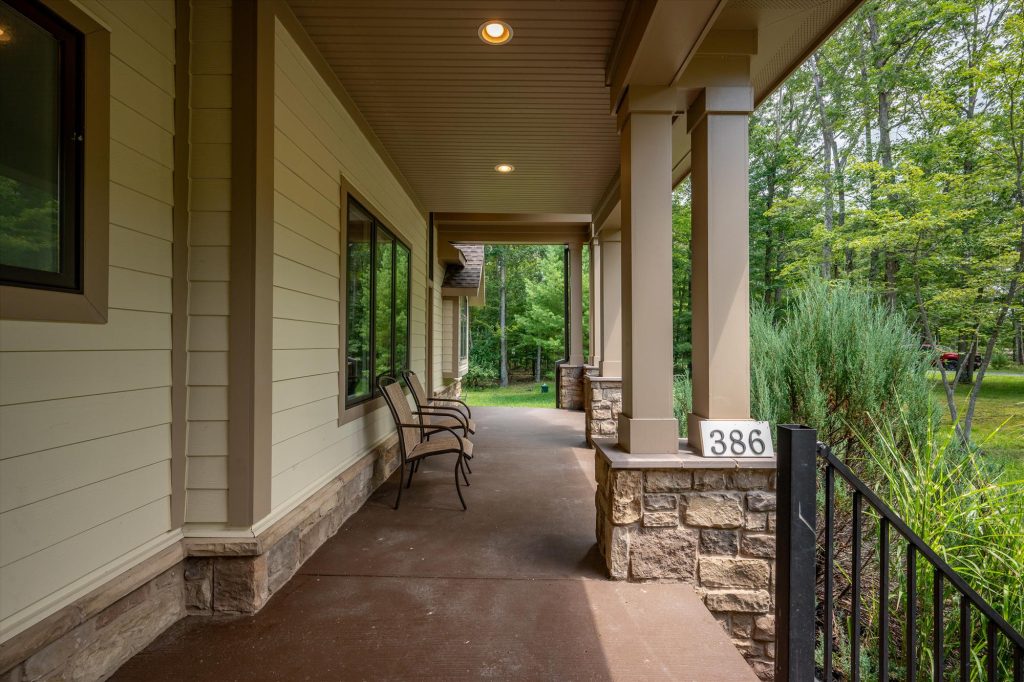 Covered front porch of Woodland Chalet with seating area overlooking the woods