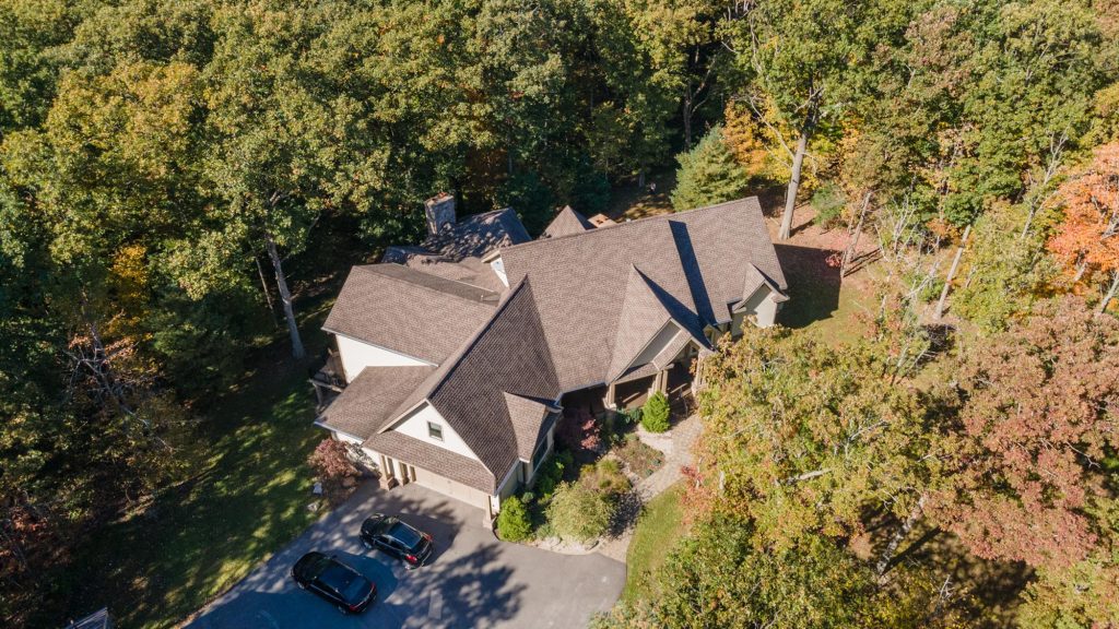 Drone shot capturing Woodland Chalet roofline and expansive deck areas from above