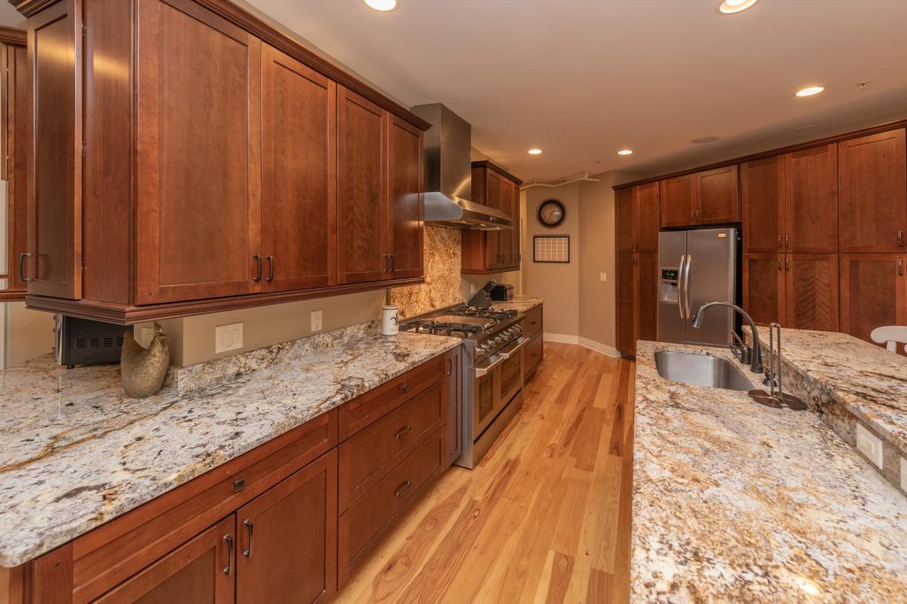 Main kitchen countertops and cabinetry with wine cooler and coffee station