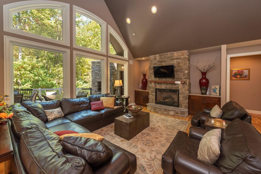 Spacious living room with stone fireplace and cathedral ceilings at Woodland Chalet