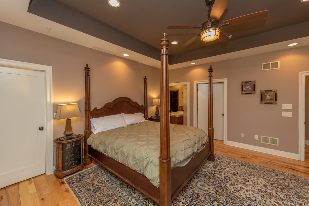 Main level master suite with king bed and elegant furnishings at Woodland Chalet