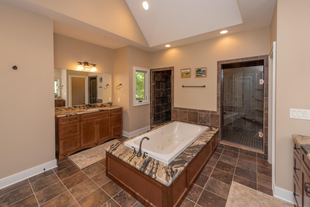 Main level master suite bathroom with double vanity and elegant finishes